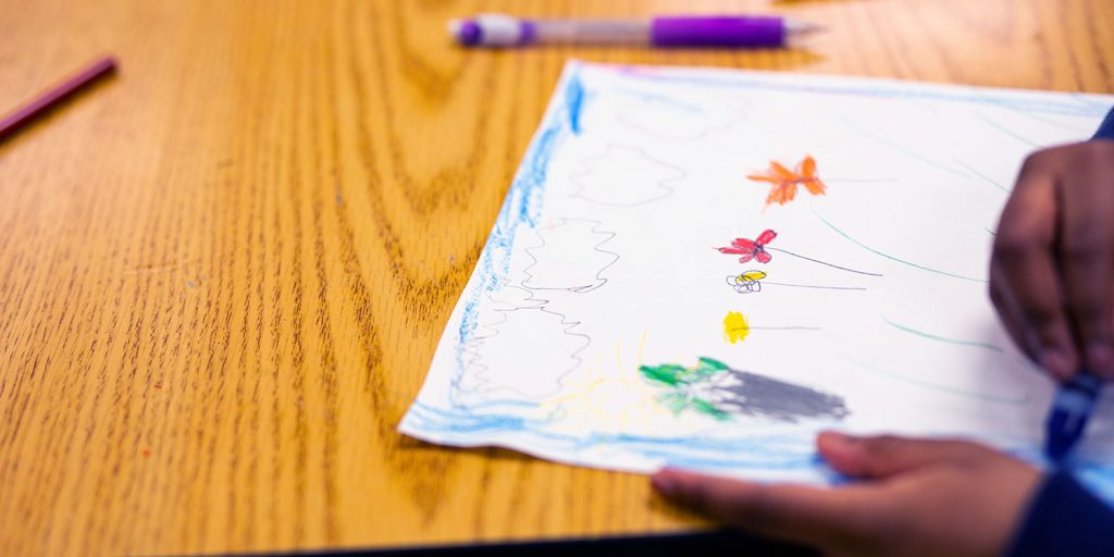 学生绘画和着色花的图片。